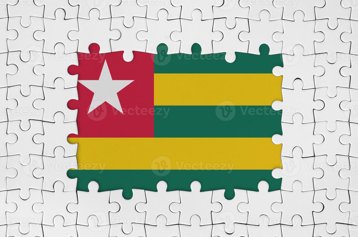 Togo flag in frame of white puzzle pieces with missing central part photo