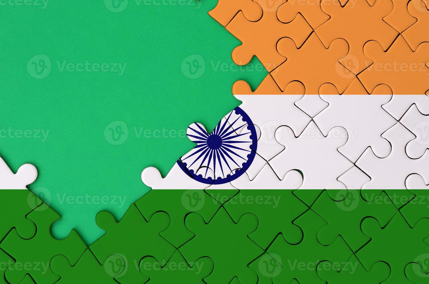 India flag  is depicted on a completed jigsaw puzzle with free green copy space on the left side photo