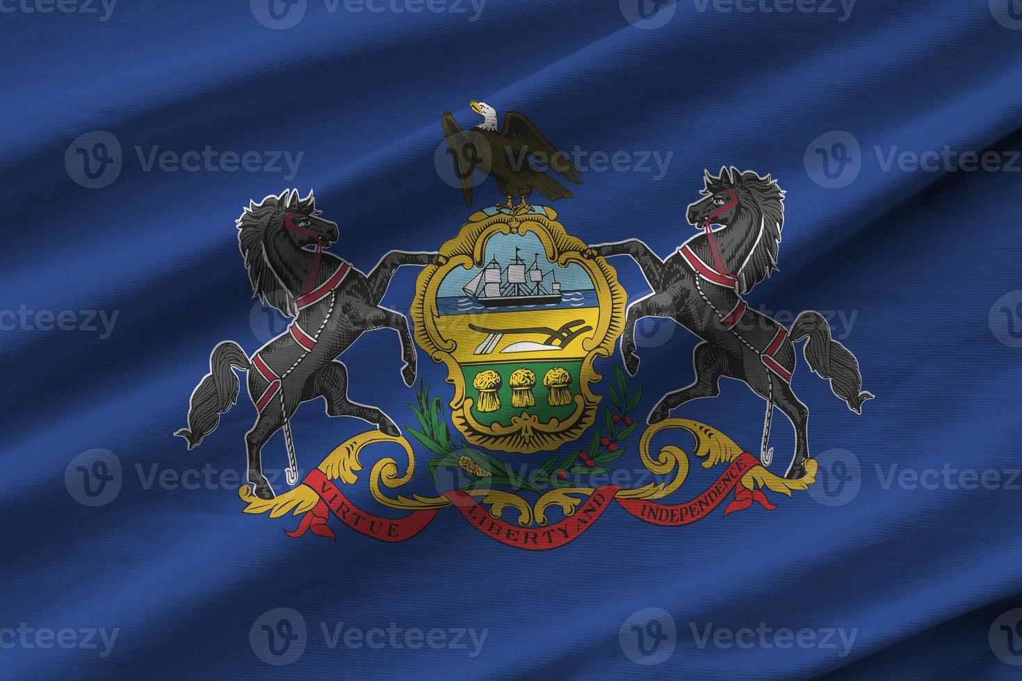 Pennsylvania US state flag with big folds waving close up under the studio light indoors. The official symbols and colors in banner photo