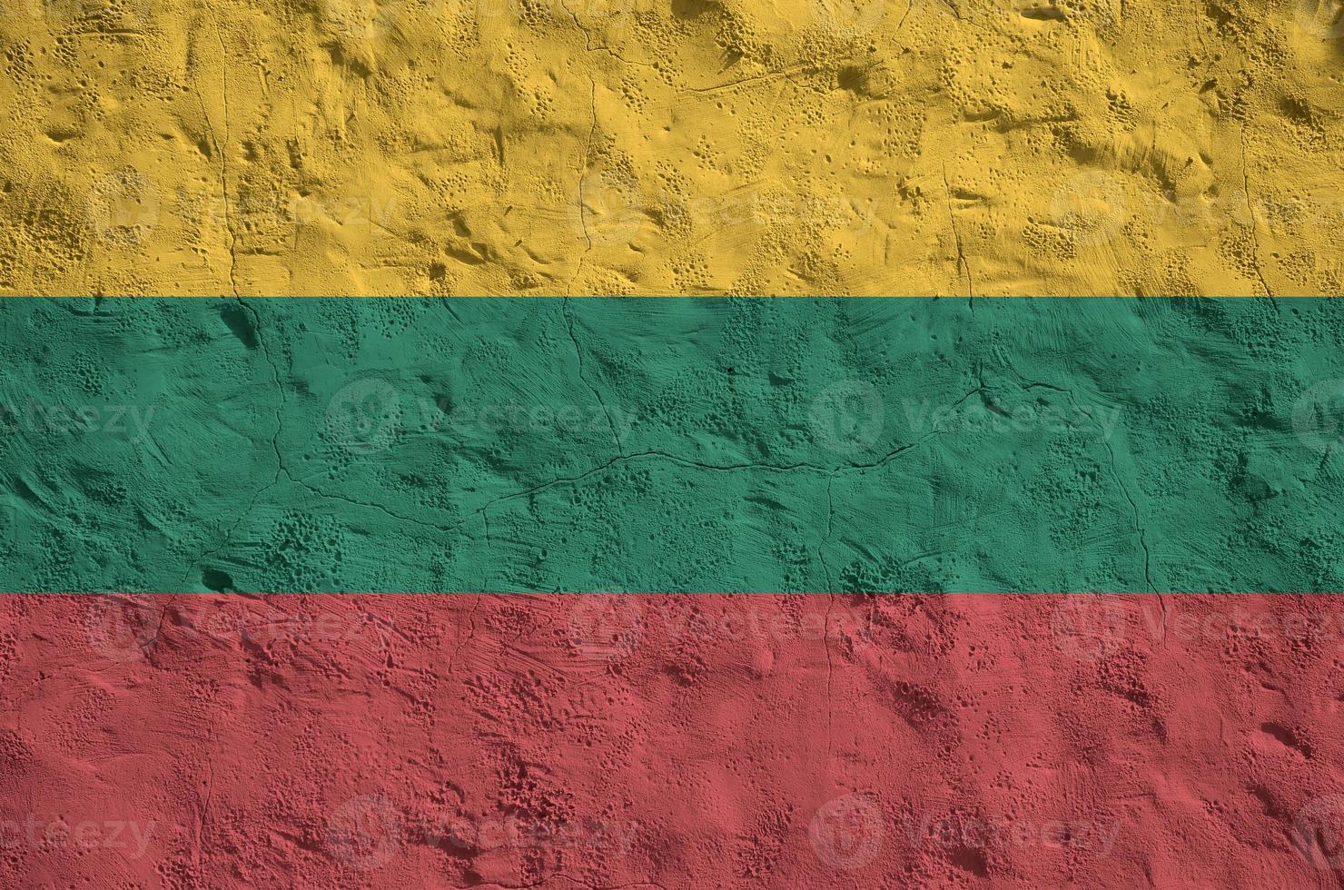 Lithuania flag depicted in bright paint colors on old relief plastering wall. Textured banner on rough background photo