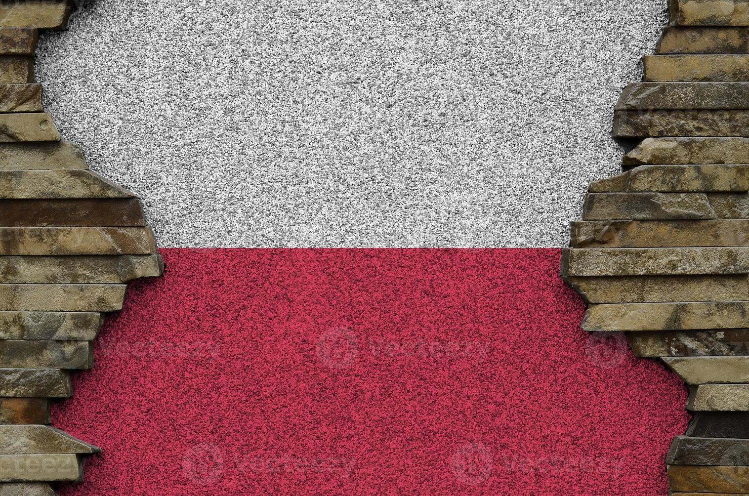 Poland flag depicted in paint colors on old stone wall closeup. Textured banner on rock wall background photo