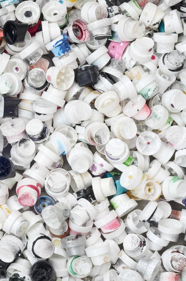 A pattern of many used and soiled nozzles from spray cans with aerosol paint. Background texture of the street art of drawing graffiti on the walls photo