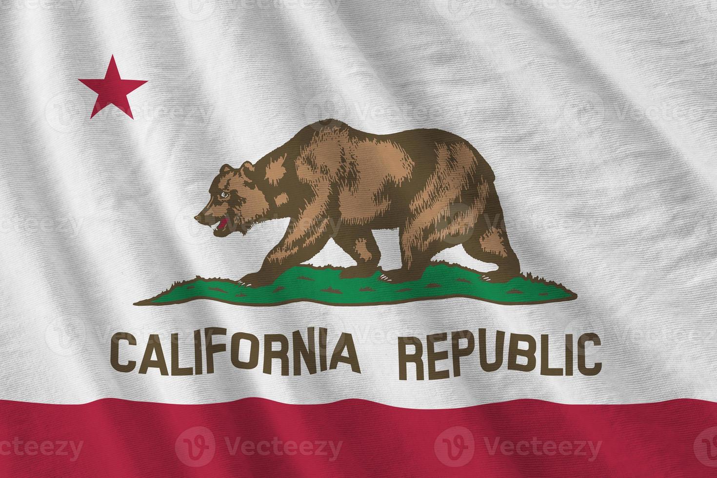 California US state flag with big folds waving close up under the studio light indoors. The official symbols and colors in banner photo