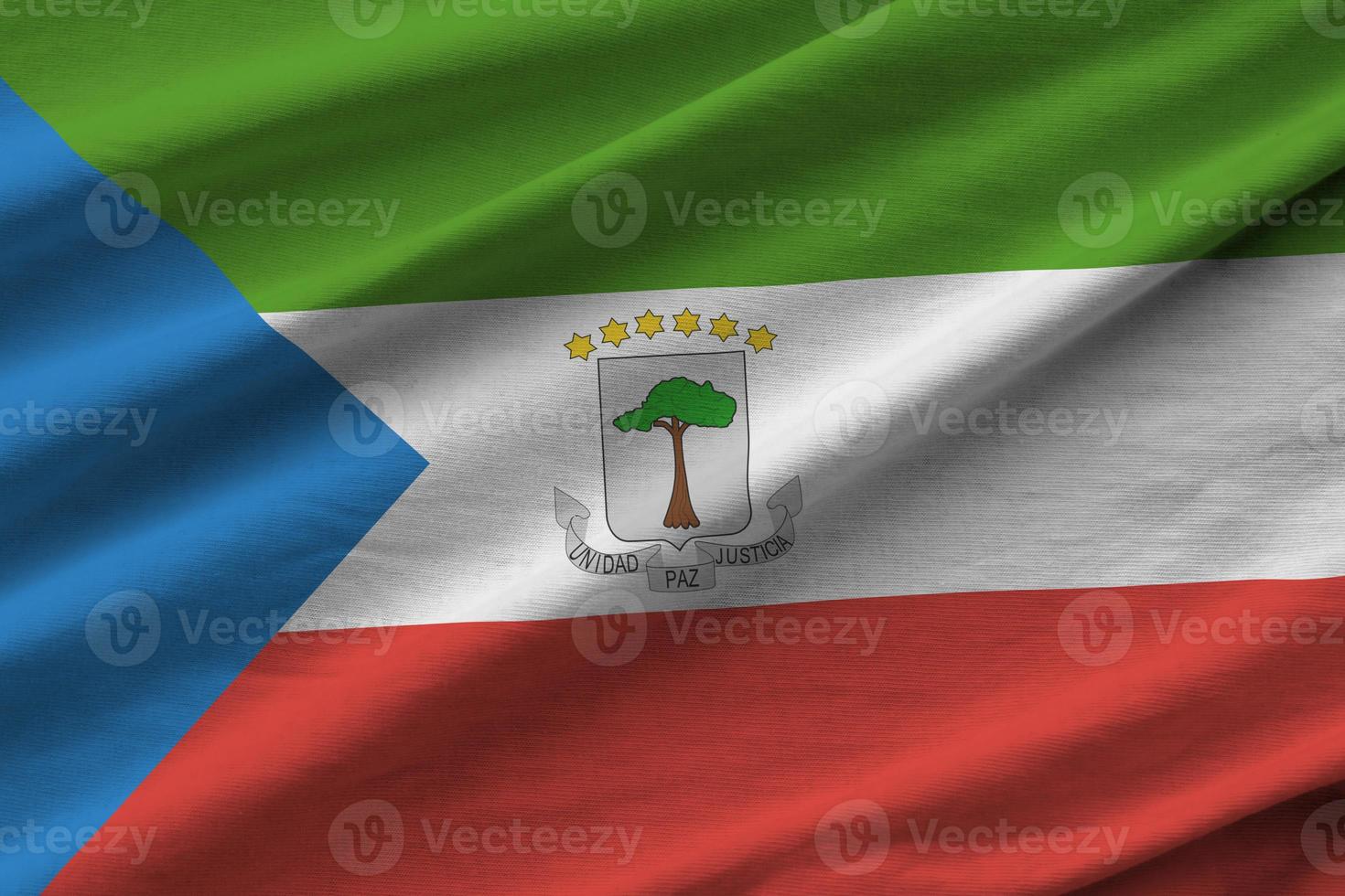 Equatorial Guinea flag with big folds waving close up under the studio light indoors. The official symbols and colors in banner photo