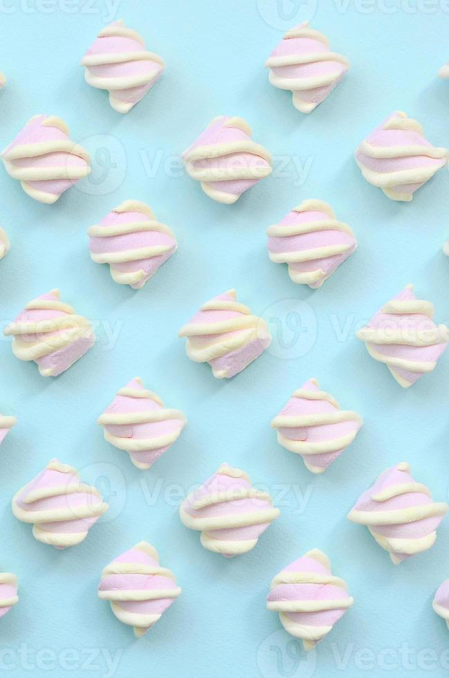 Colorful marshmallow laid out on blue paper background. pastel creative textured pattern. minimal photo