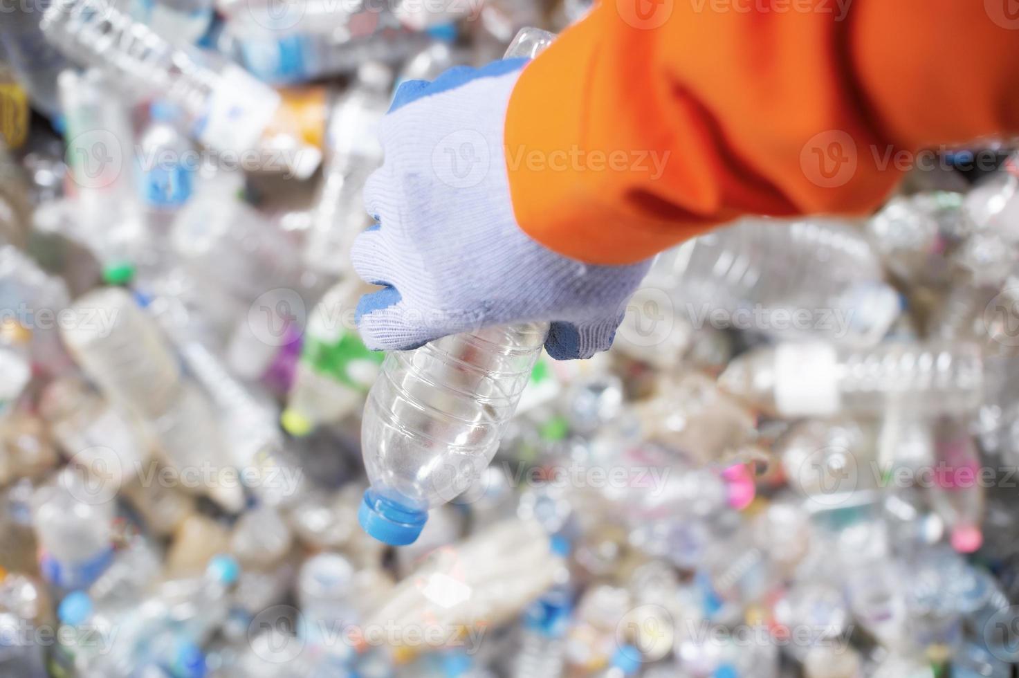 cerrar la mano del trabajador con la separación de la industria de reciclaje de botellas de plástico foto