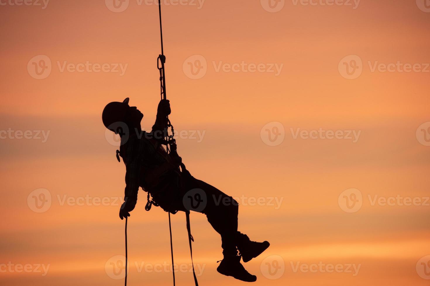 rescate de silueta en una cuerda al atardecer foto