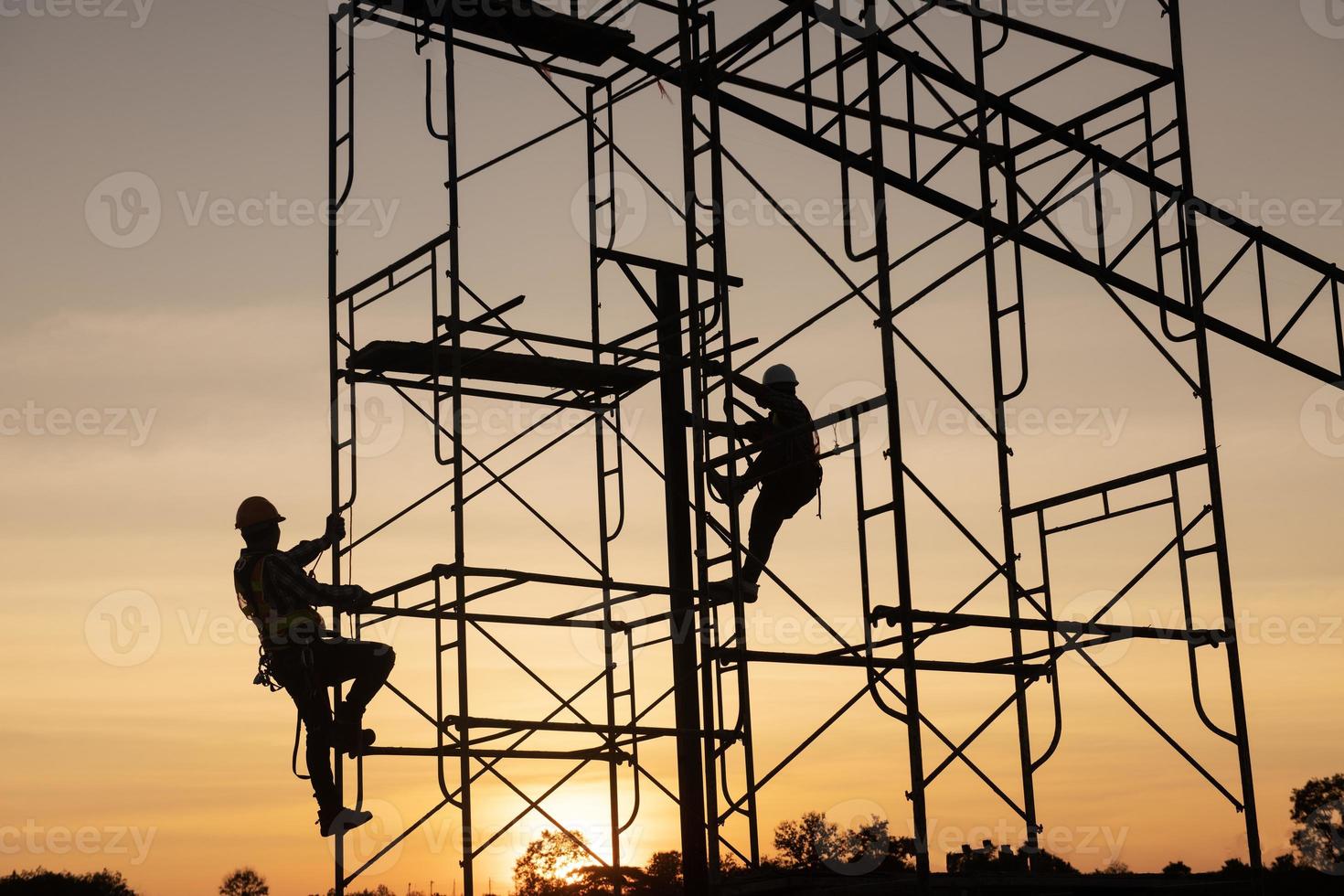 teamwork construction worker installation scaffolding in industrial construction sunset sky background overtime job Silhouette. photo