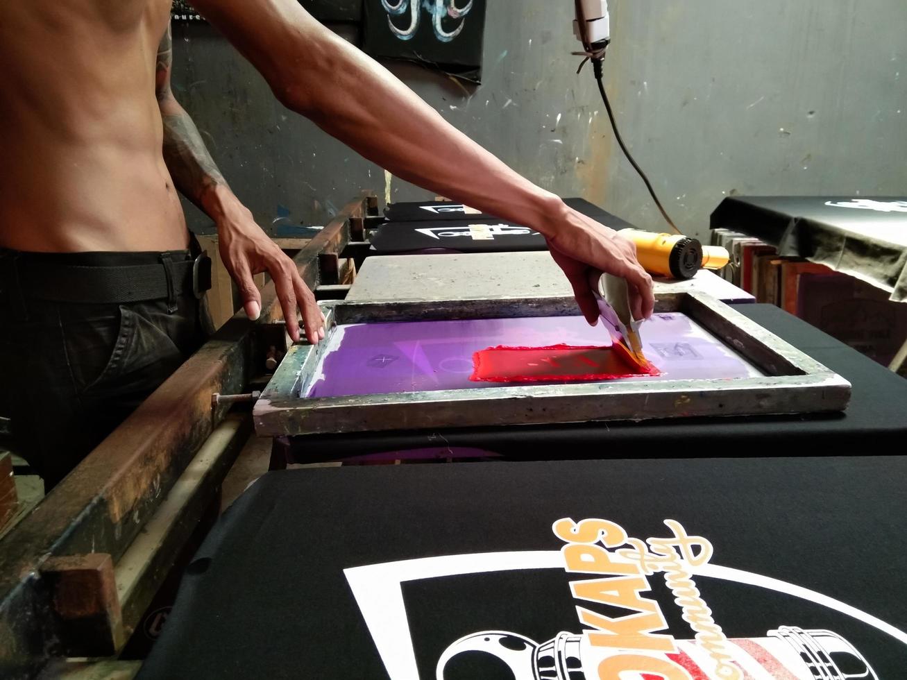 Probolinggo,Indonesia. August.10,2022-a manual screen printing worker is working amidst the onslaught of technological sophistication photo