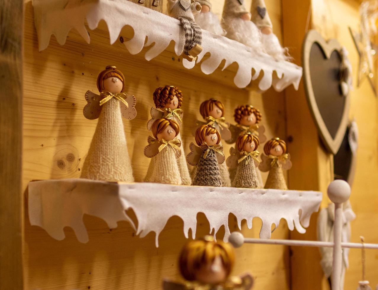 Market stall showing an assortment of handmade Angle figures at traditional famous christmas market Christkindlmarkt at Merano South Tyrol Italy photo