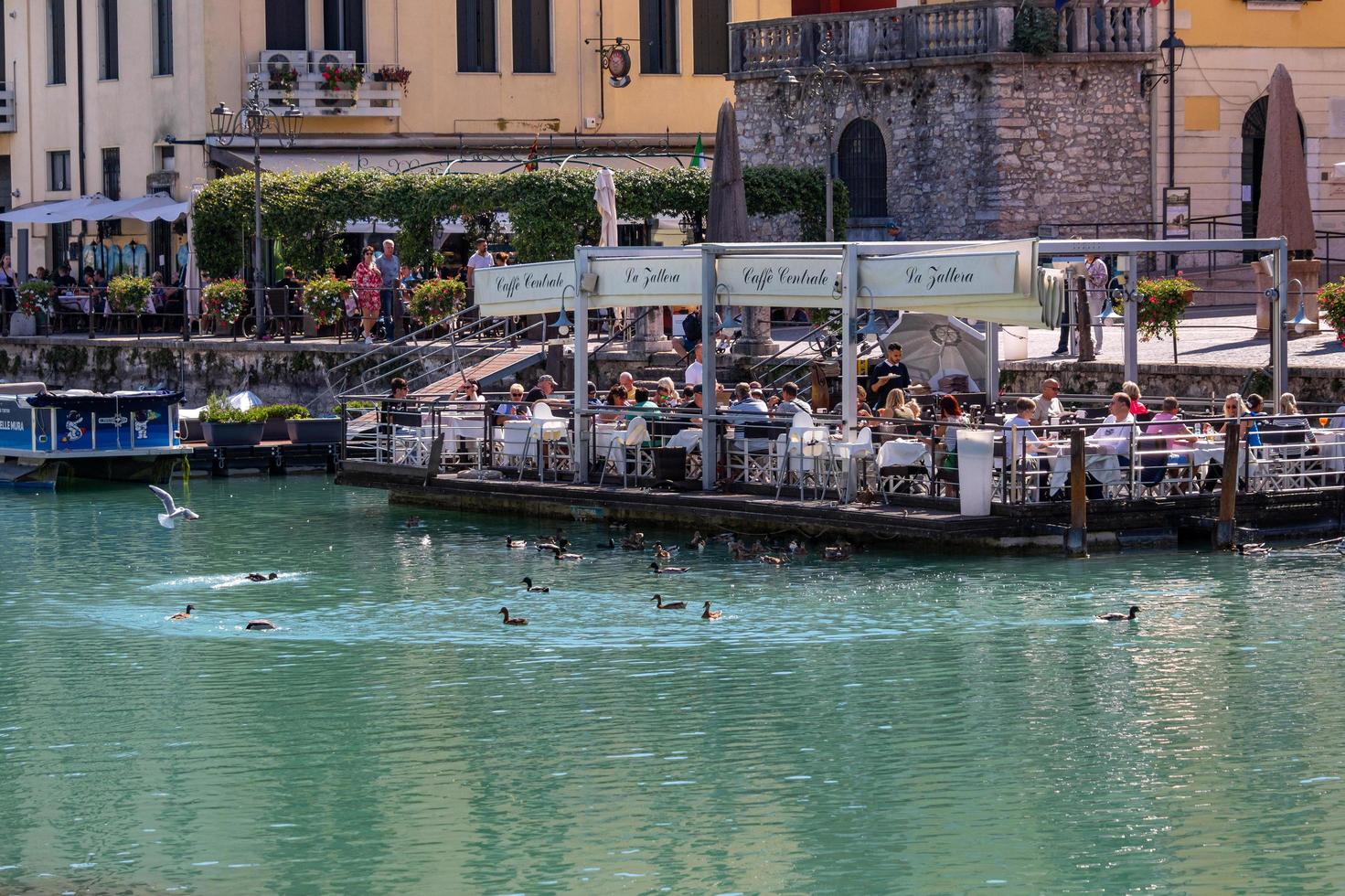 Peschiera del Garda, Verona, Italy - 22 September 2022 Beautiful cityscape with houses and boats at Canale di mezzo at Peschiera, Lago del Garda photo