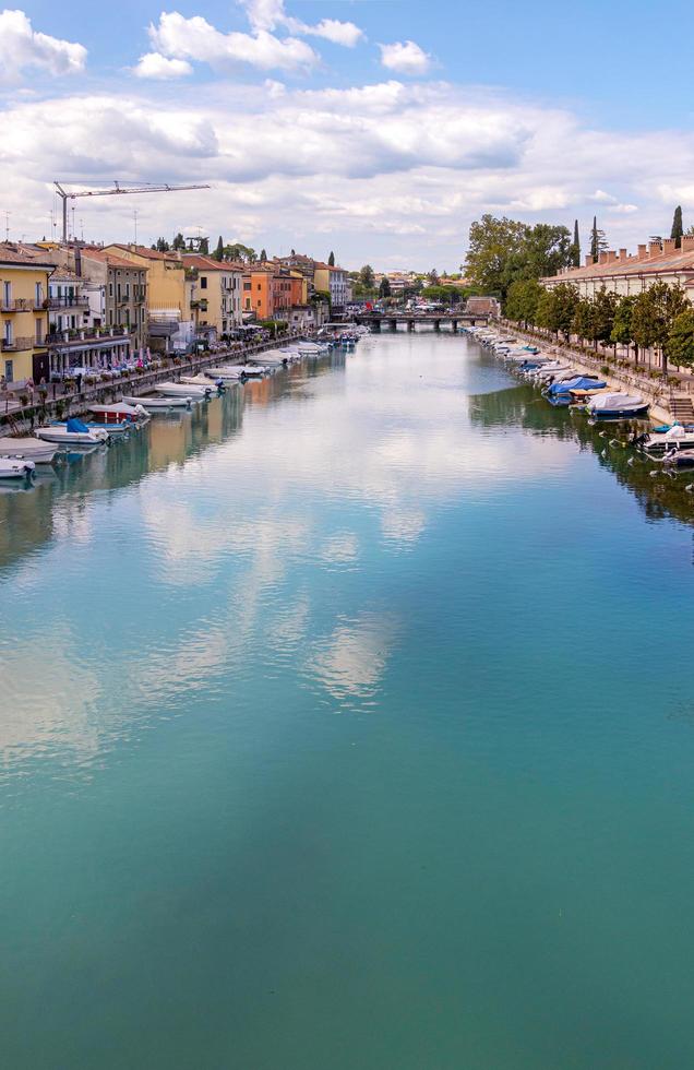 peschiera del garda, verona, italia - 22 de septiembre de 2022 hermoso paisaje urbano con casas y barcos en canale di mezzo en peschiera, lago del garda foto