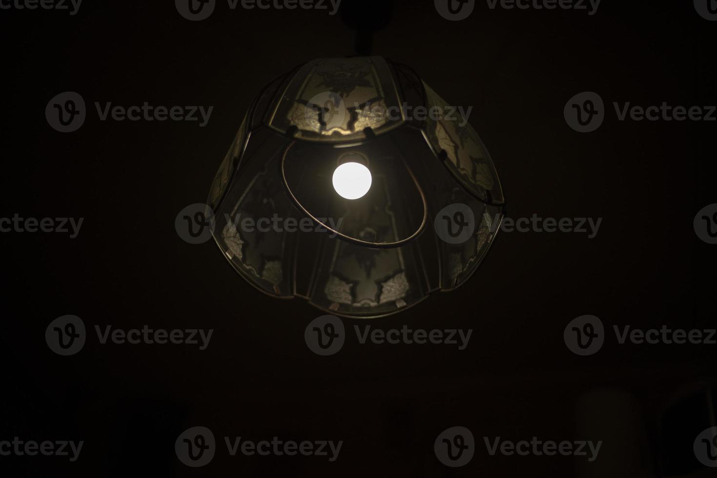 Lamp in dark. Chandelier with one lamp. Light source. photo