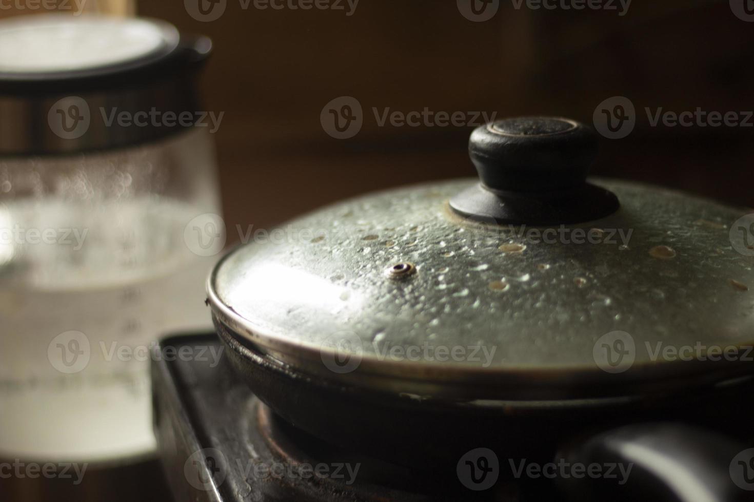 Frying pan with lid in kitchen. Frying pan with swollen glass. Interior of kitchen. photo