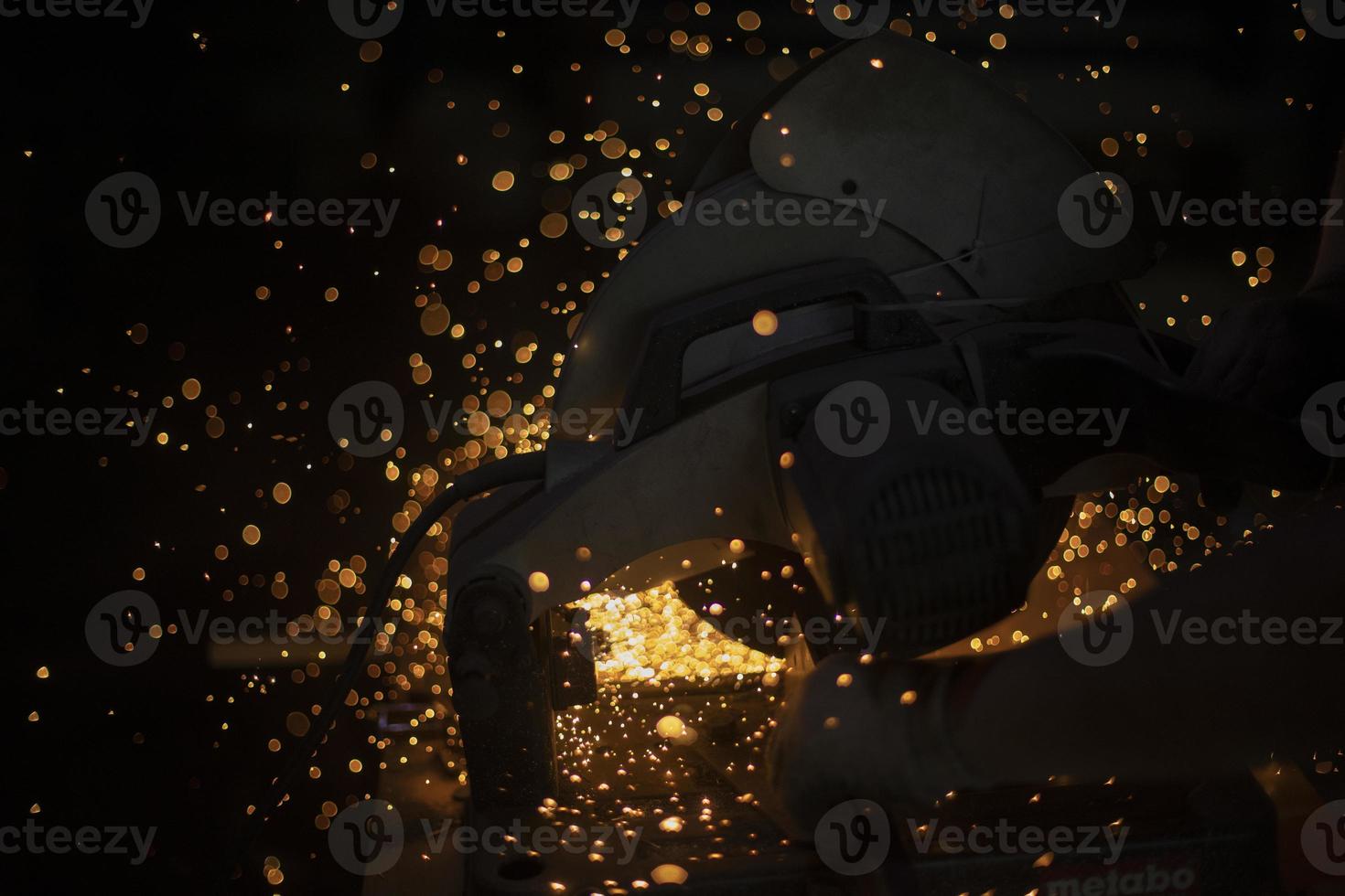 Lights in dark. Sparks from sawing metal. Industrial background. photo