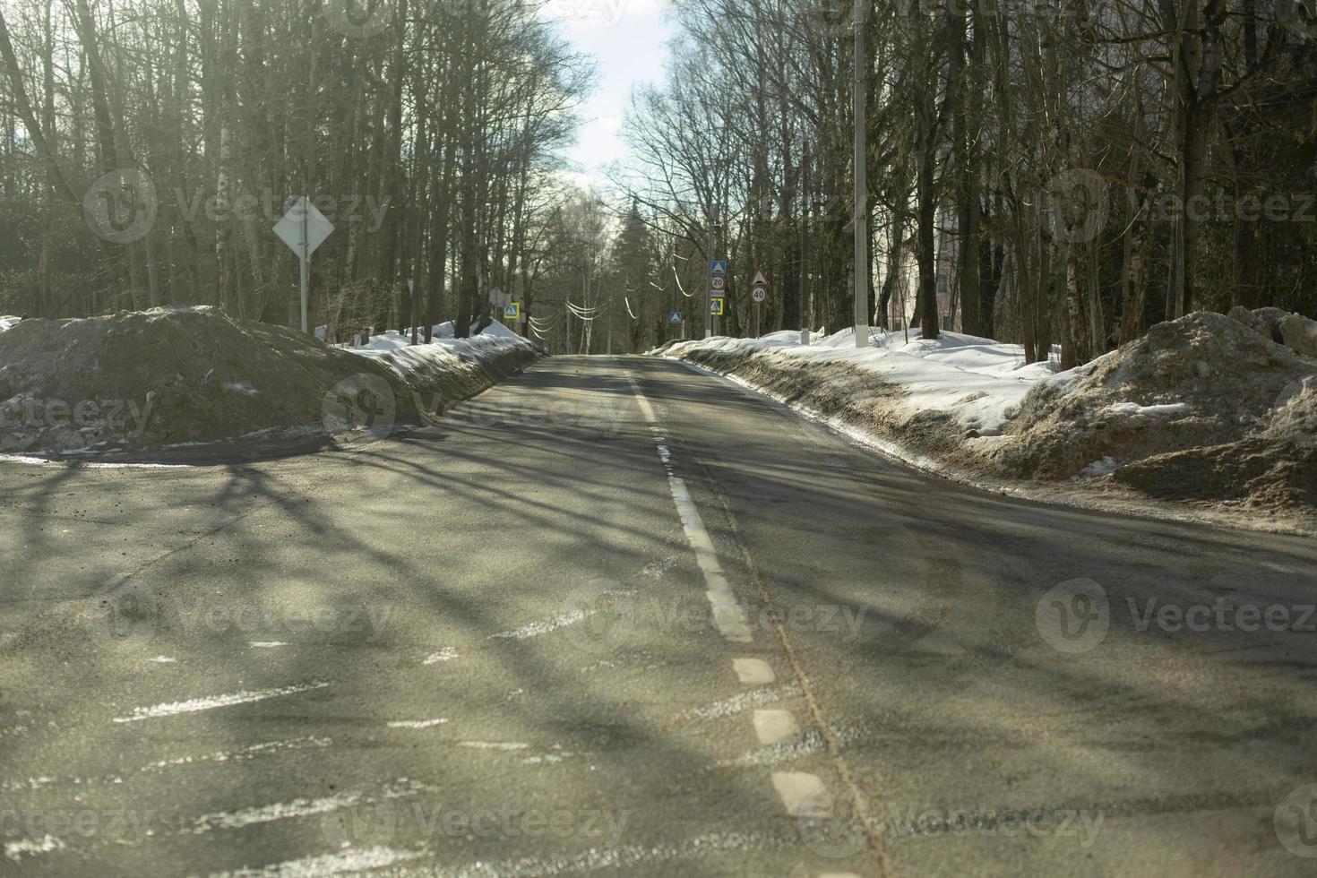 Road in winter. Highway in sunlight. Street in park. Place to go. photo