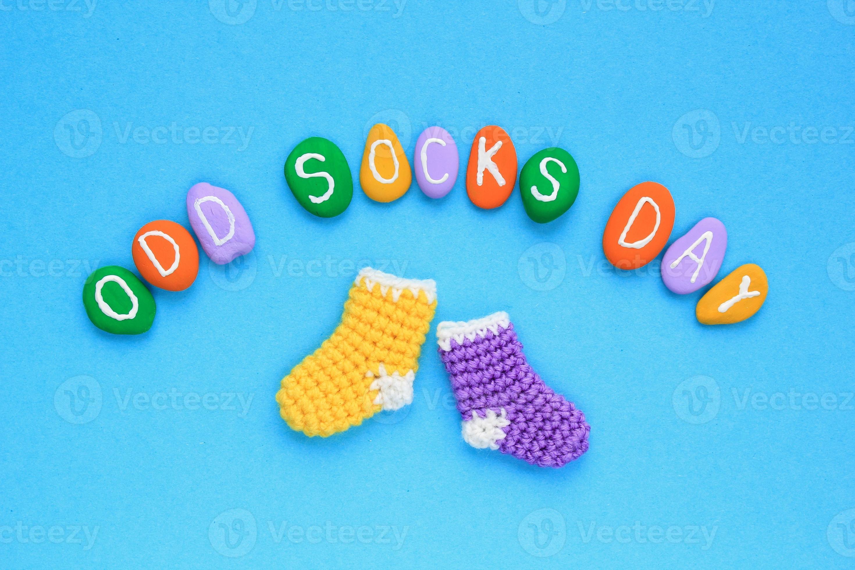 Odd socks day lettering and mismatched colourful socks on blue