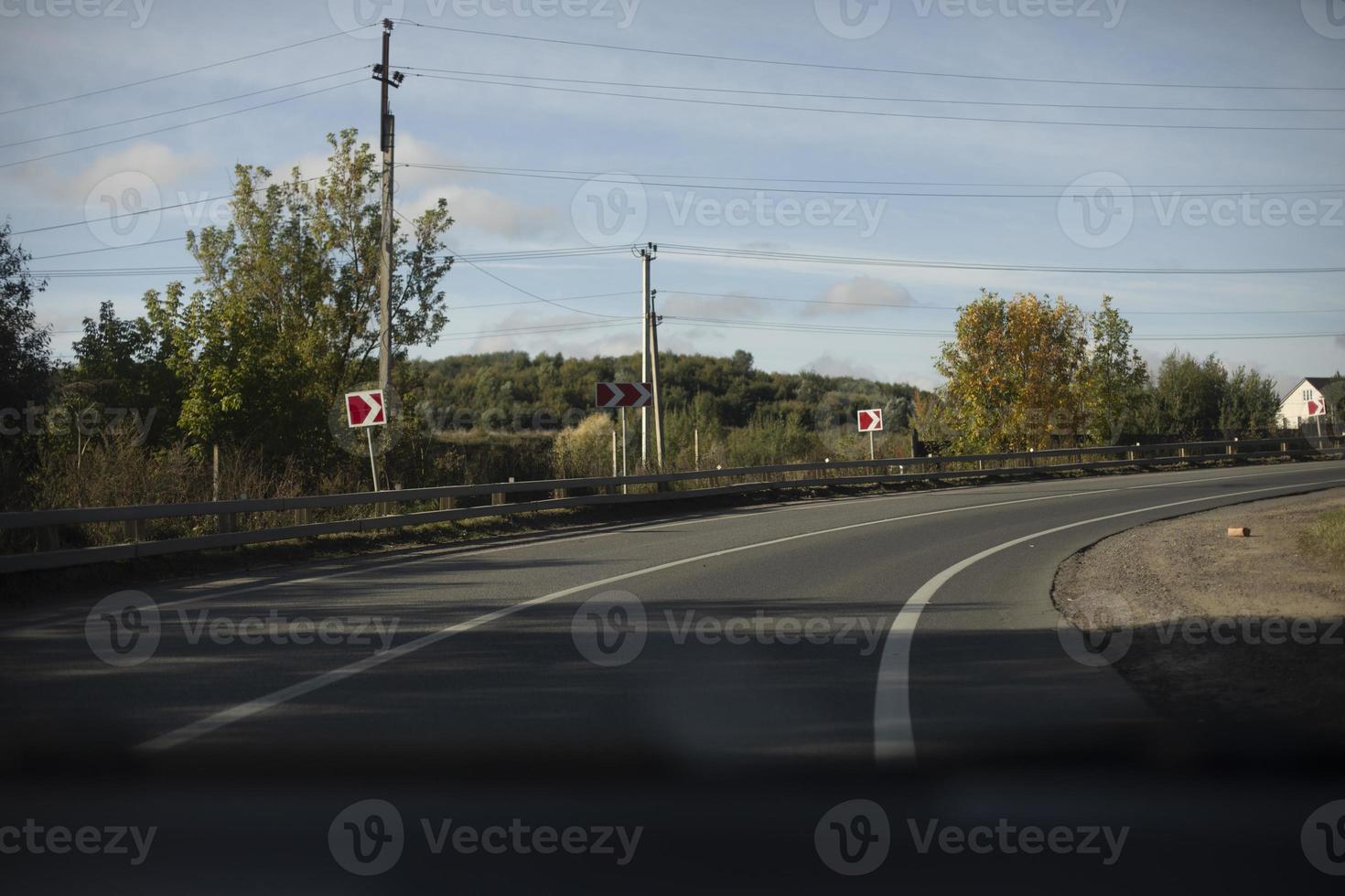 Sharp turn of road. Bending of road with markings. Red turn signs. photo