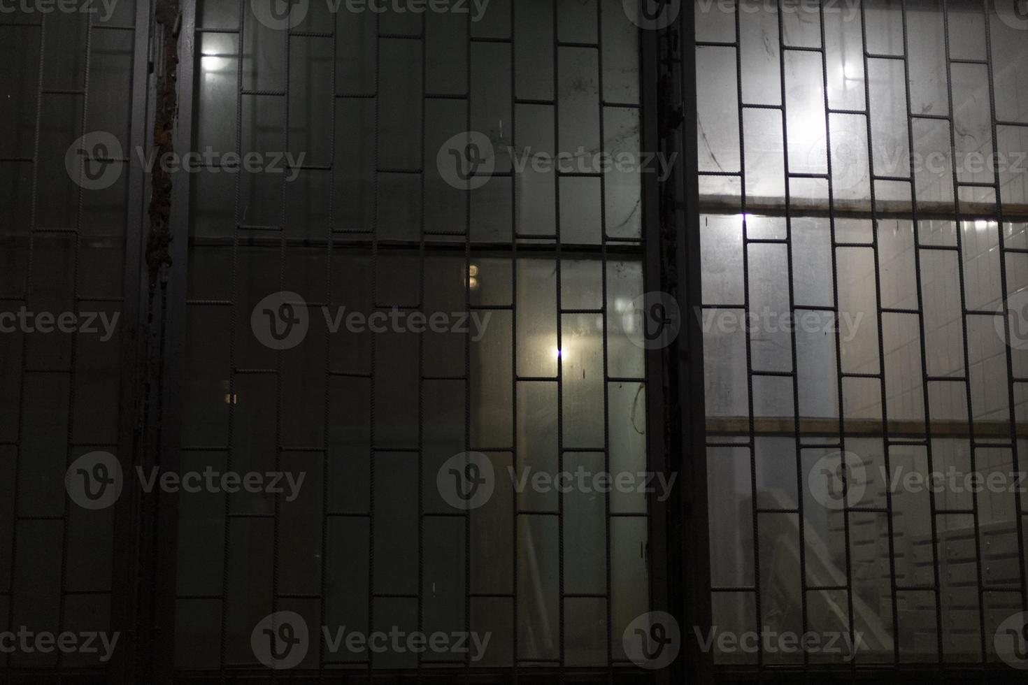 Grille on window at night. Window with lattice. Entrance to entrance in evening. photo