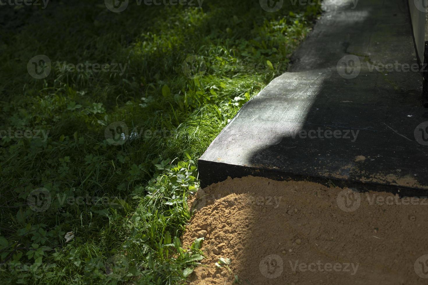 Sand at base of building. Wall of house. Building threshold. photo