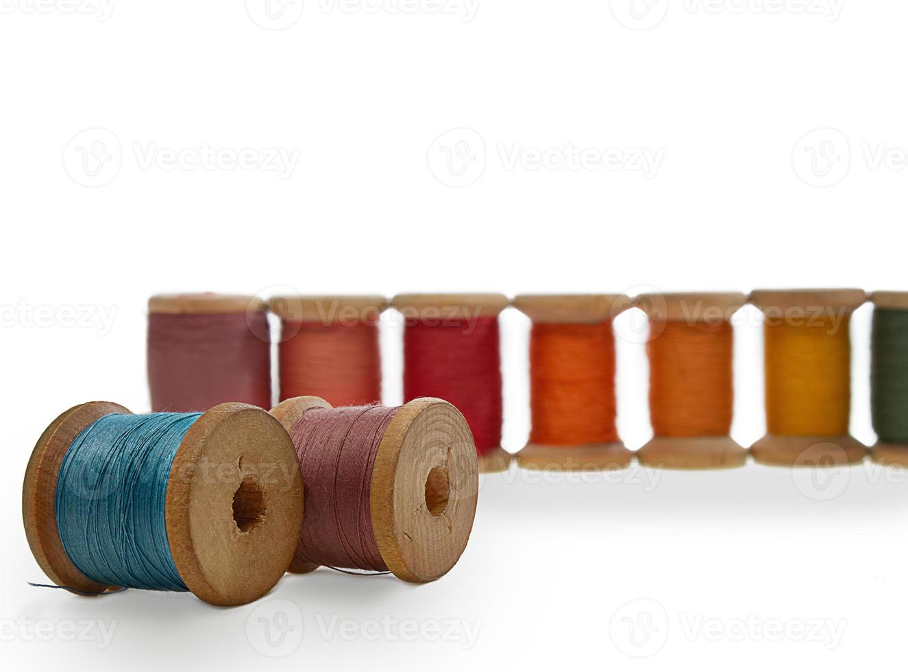 Spools of wooden thread. Blue and lilac lie, red stand in a row. Sewing, repairing clothes. Copy space photo