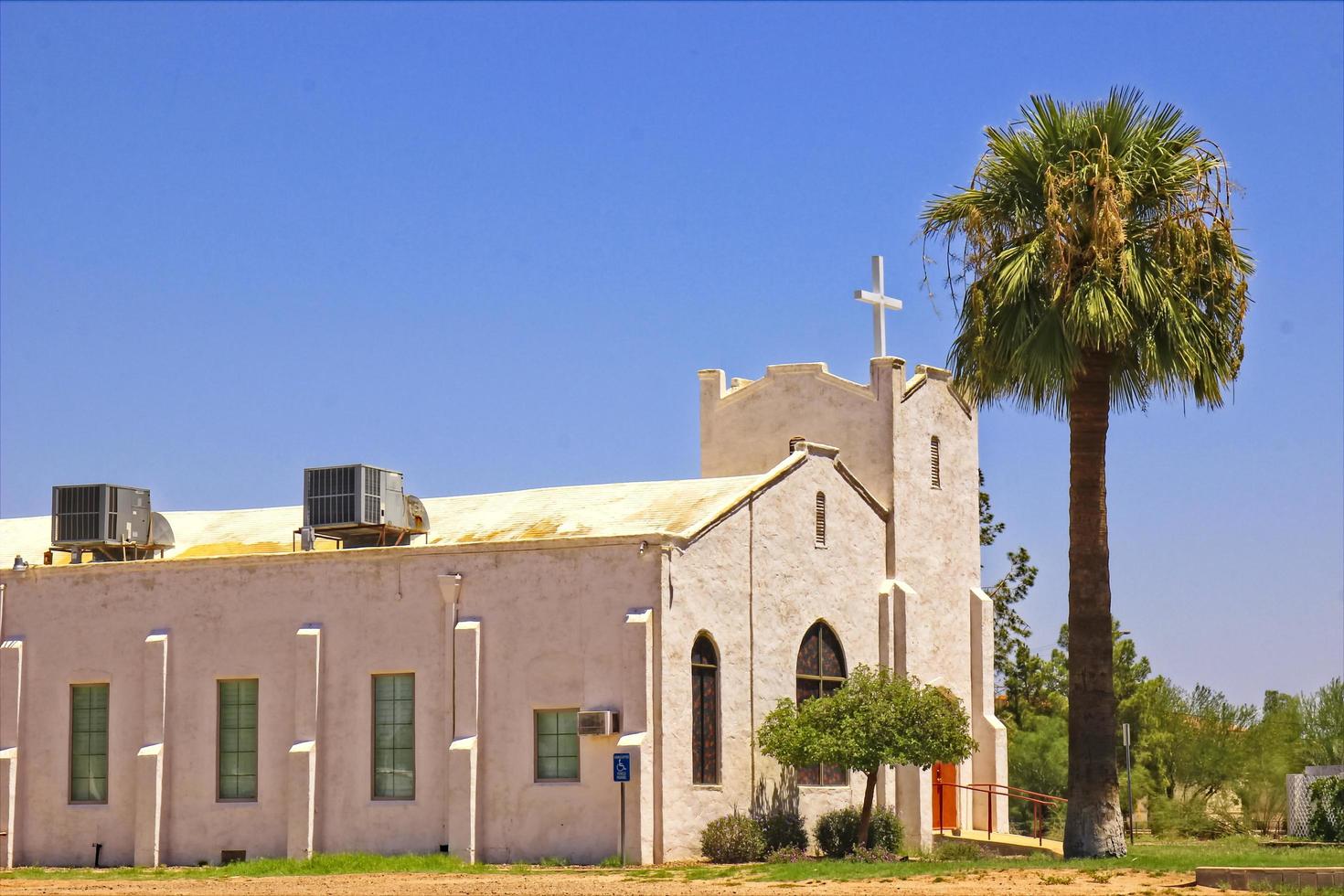antigua iglesia de estuco con palmera solitaria foto