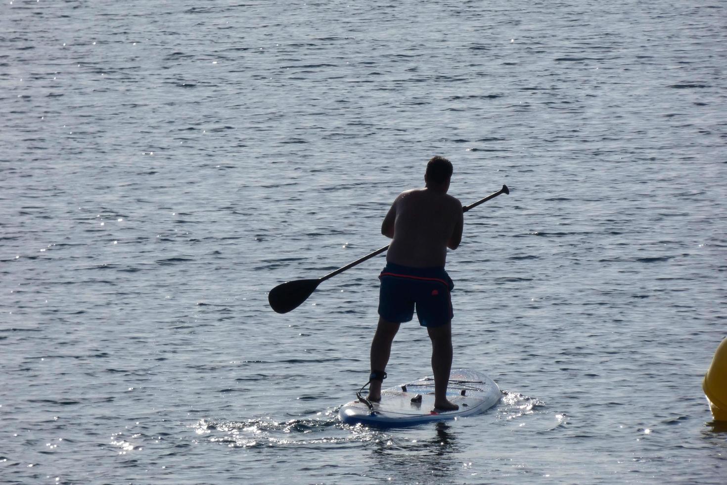 swimmer on vacation paddle surfing in the mediterranean sea photo