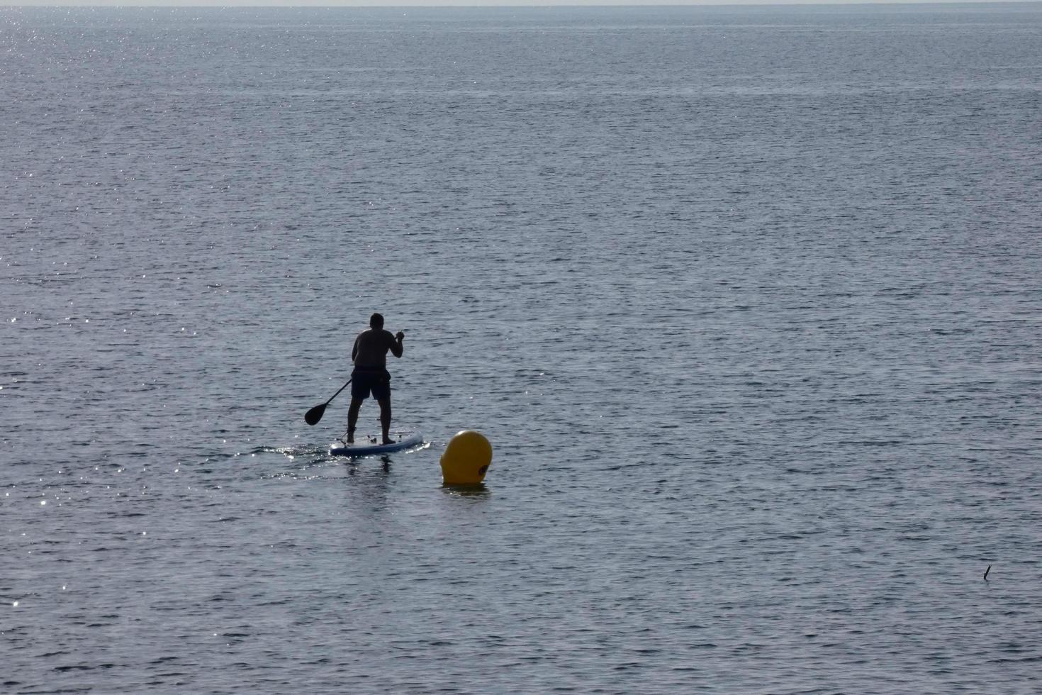 swimmer on vacation paddle surfing in the mediterranean sea photo