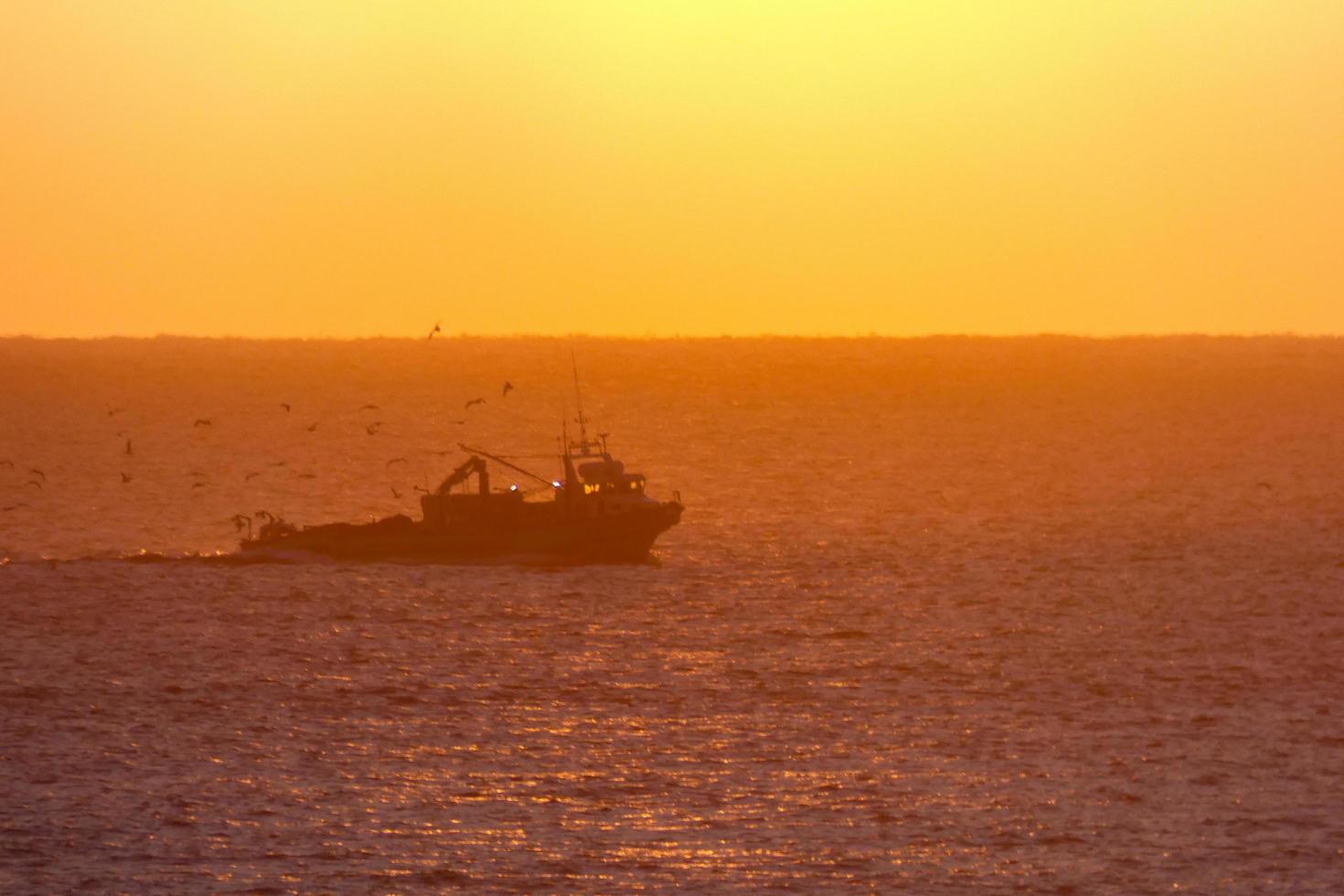 pescadores que regresan de pesca al amanecer después de pasar toda la noche en el mar. foto