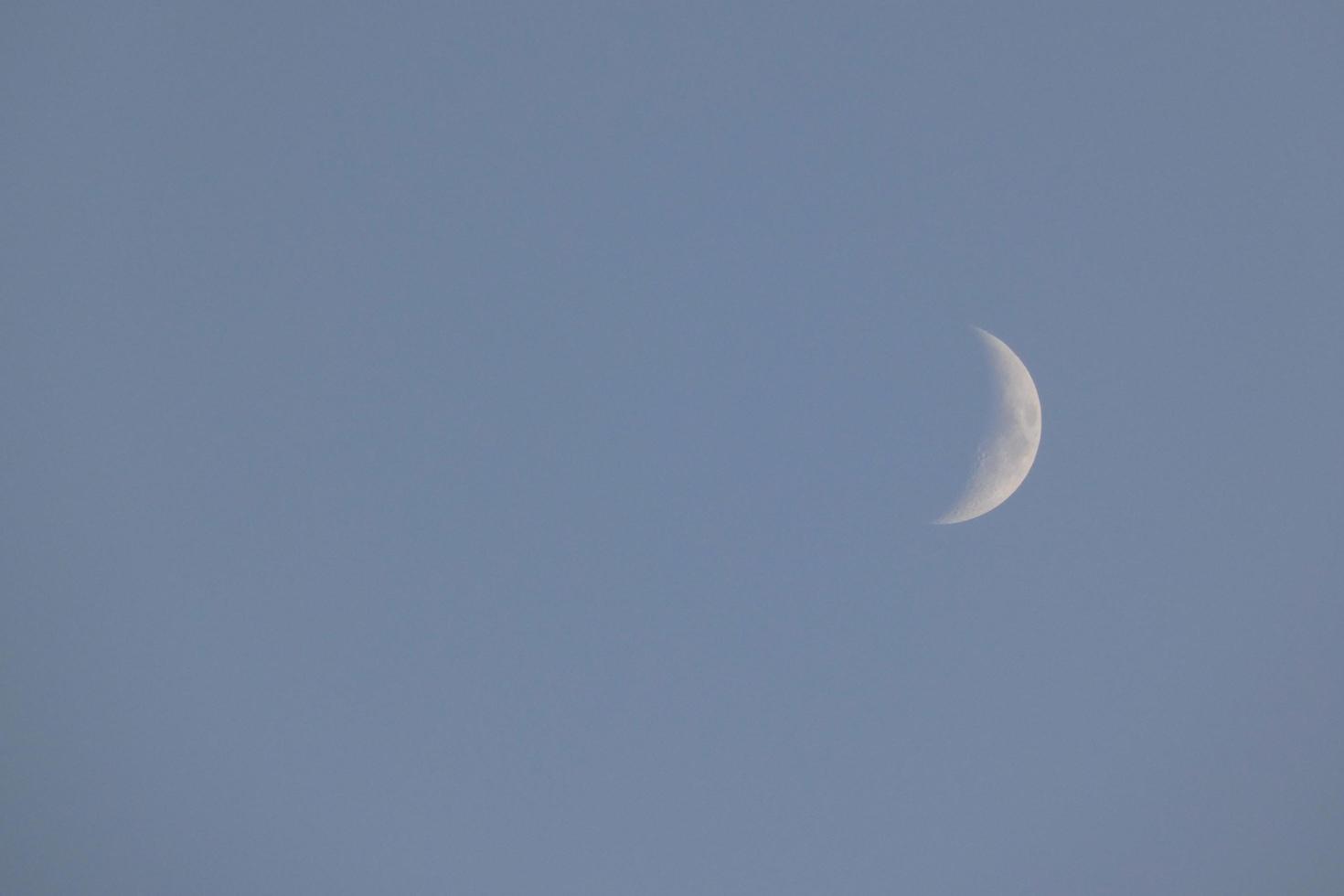 Crescent moon under the blue sky photo