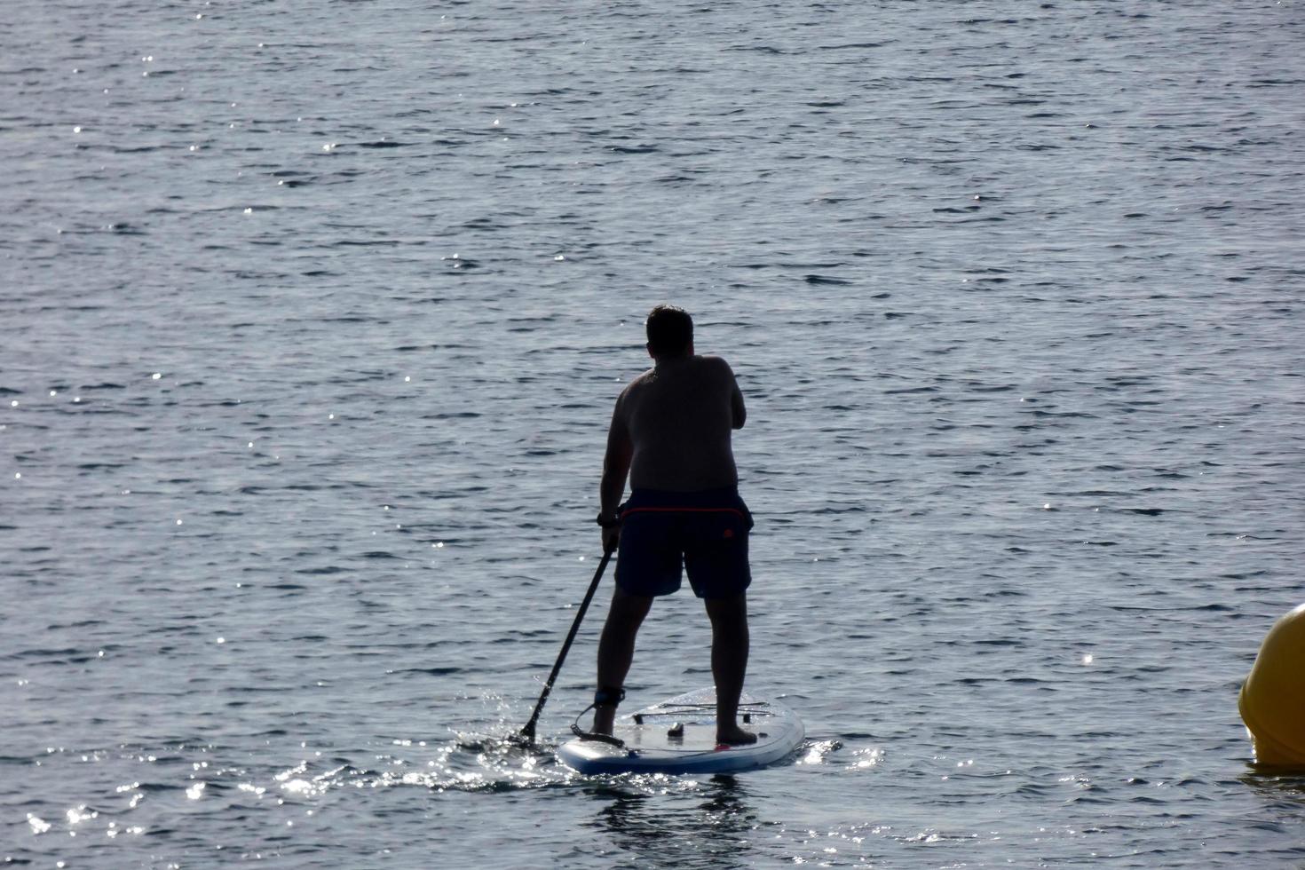 swimmer on vacation paddle surfing in the mediterranean sea photo