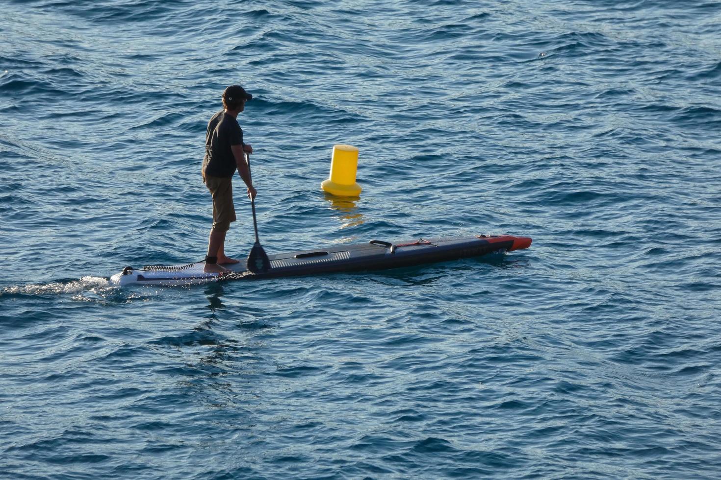 swimmer on vacation paddle surfing in the mediterranean sea photo