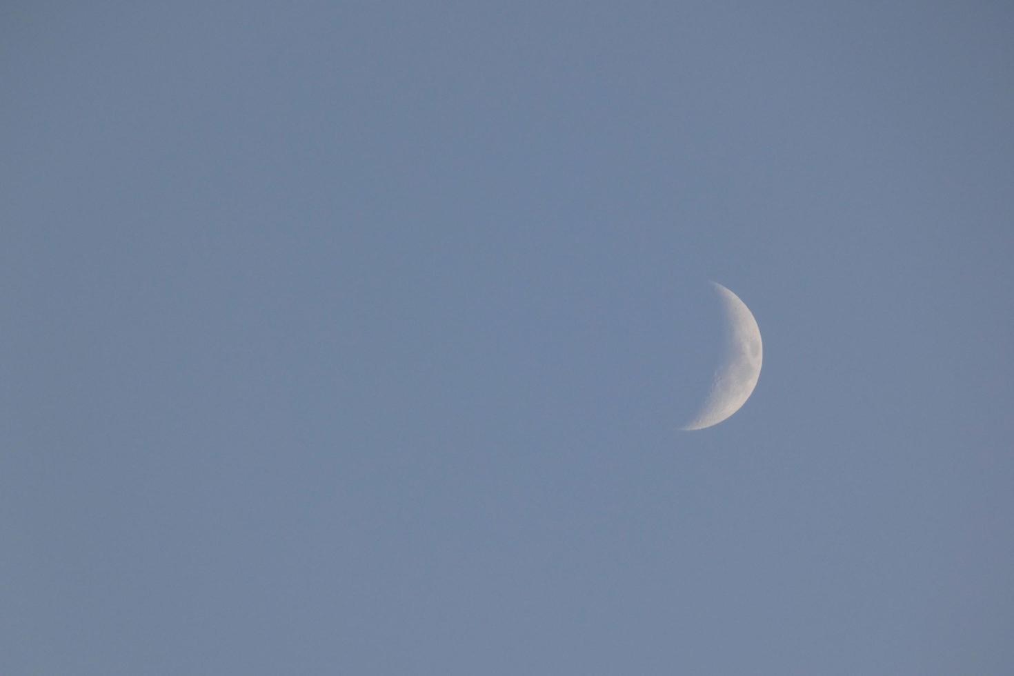 Crescent moon under the blue sky photo