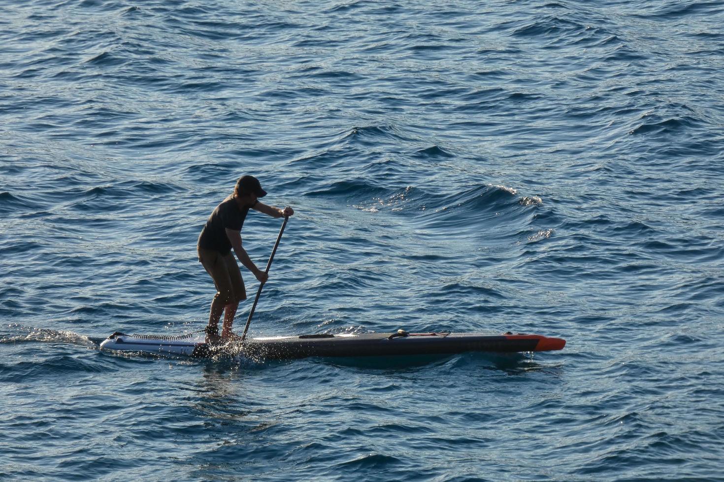 swimmer on vacation paddle surfing in the mediterranean sea photo