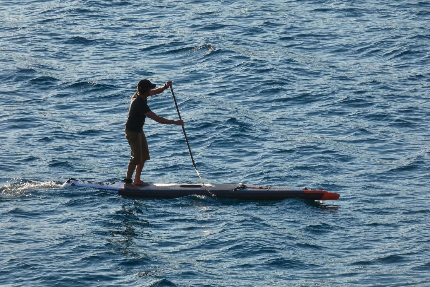 swimmer on vacation paddle surfing in the mediterranean sea photo