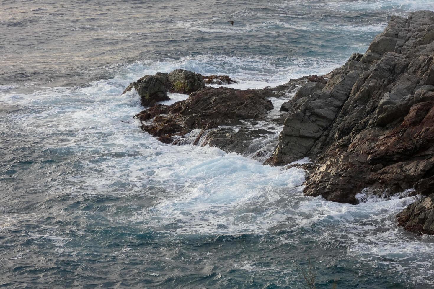 Sea reaching the rocks creating splashes of foam photo