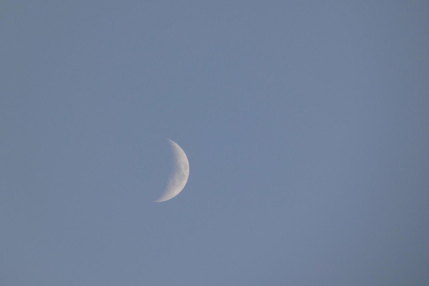 luna creciente bajo el cielo azul foto