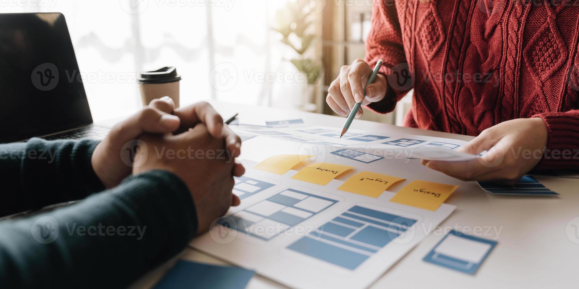 grupo de lluvia de ideas de concepto de trabajo de personas. lluvia de ideas del equipo de negocios. investigación del plan de marketing. papeleo en la mesa, computadora portátil y teléfono móvil. foto