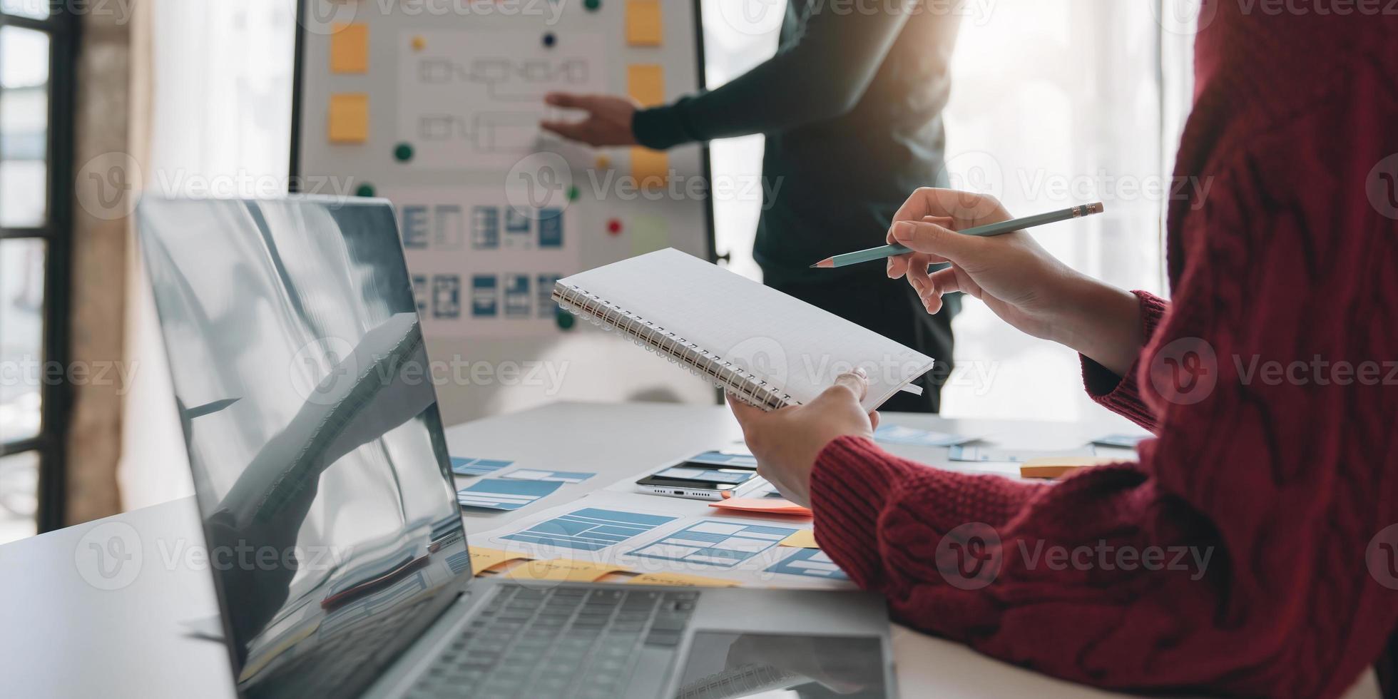 Ux developer and ui designer brainstorming about mobile app interface wireframe design on table with customer breif and color code at modern office.Creative digital development agency photo