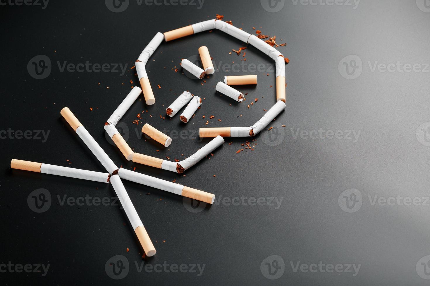 Skull from cigarettes on a black background. The concept of smoking kills. Toward the concept of smoking as a deadly habit, nicotine poisons, cancer from smoking, illness, quit smoking. photo