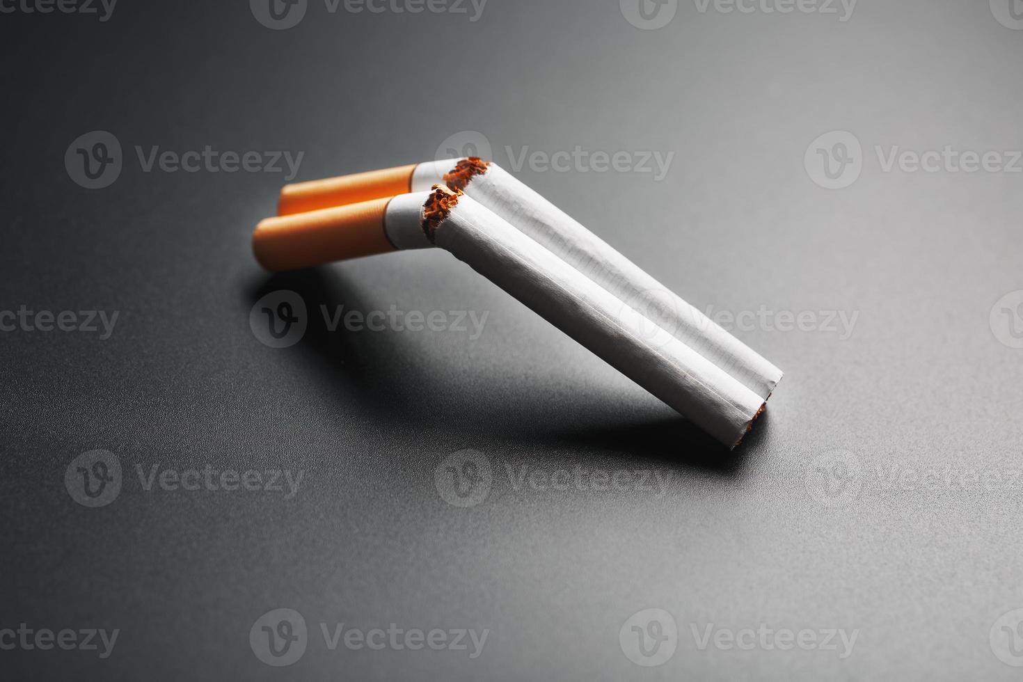 dos cigarrillos en forma de escopeta de dos cañones sobre un fondo negro con espacio para copiar. deja de fumar. el concepto de fumar mata. foto