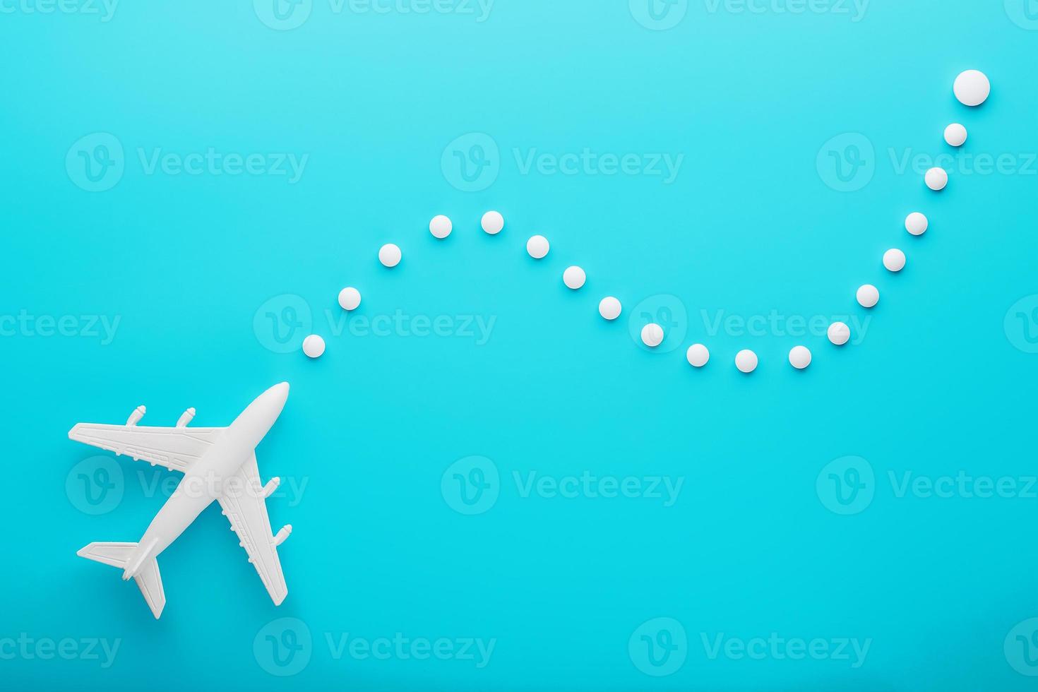 White plane on a blue background with a flexible and smooth trajectory of the route from white points. photo