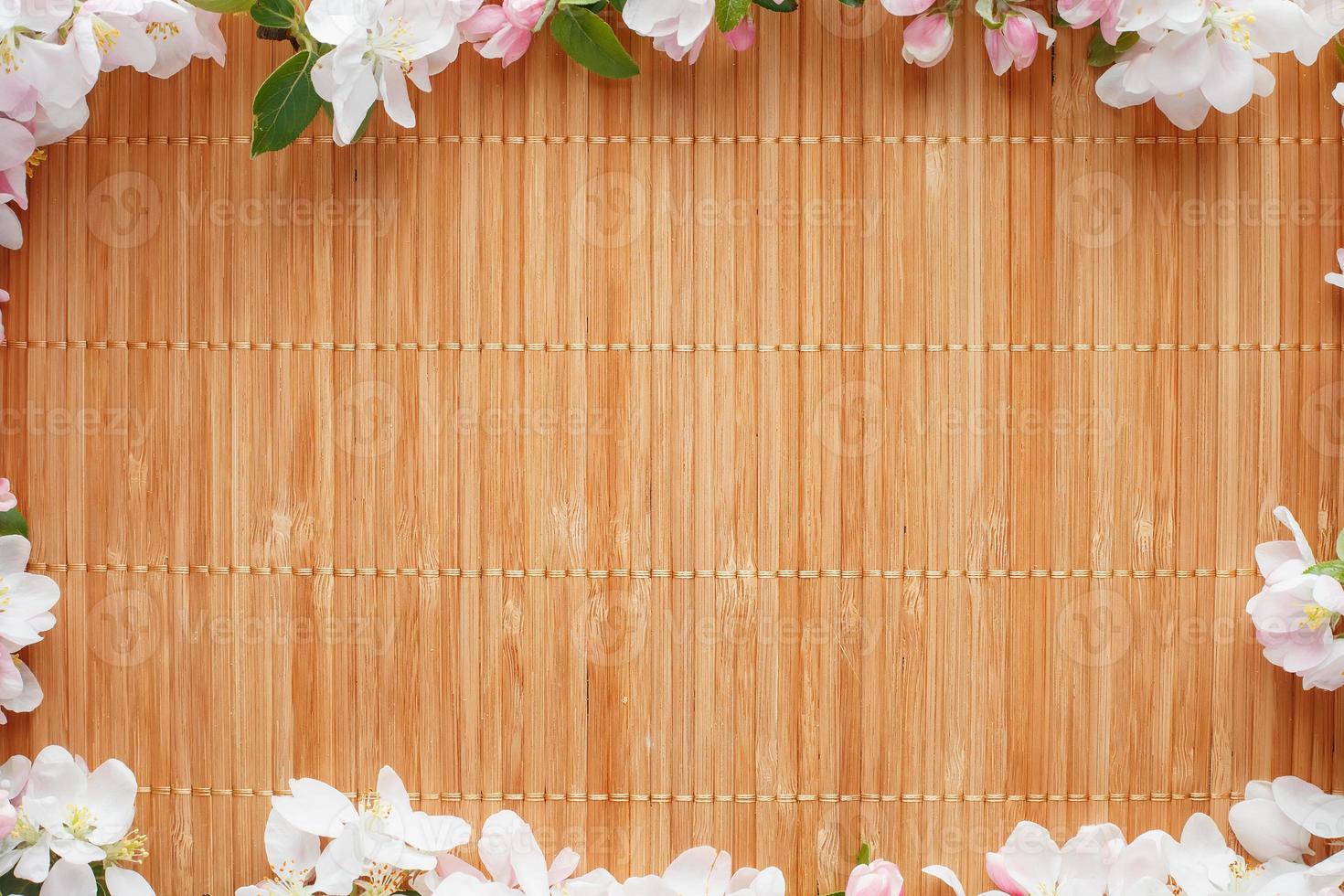 Frame of spring flowers of sakura on bamboo background. Beautiful cherry blossom sakura in springtime photo