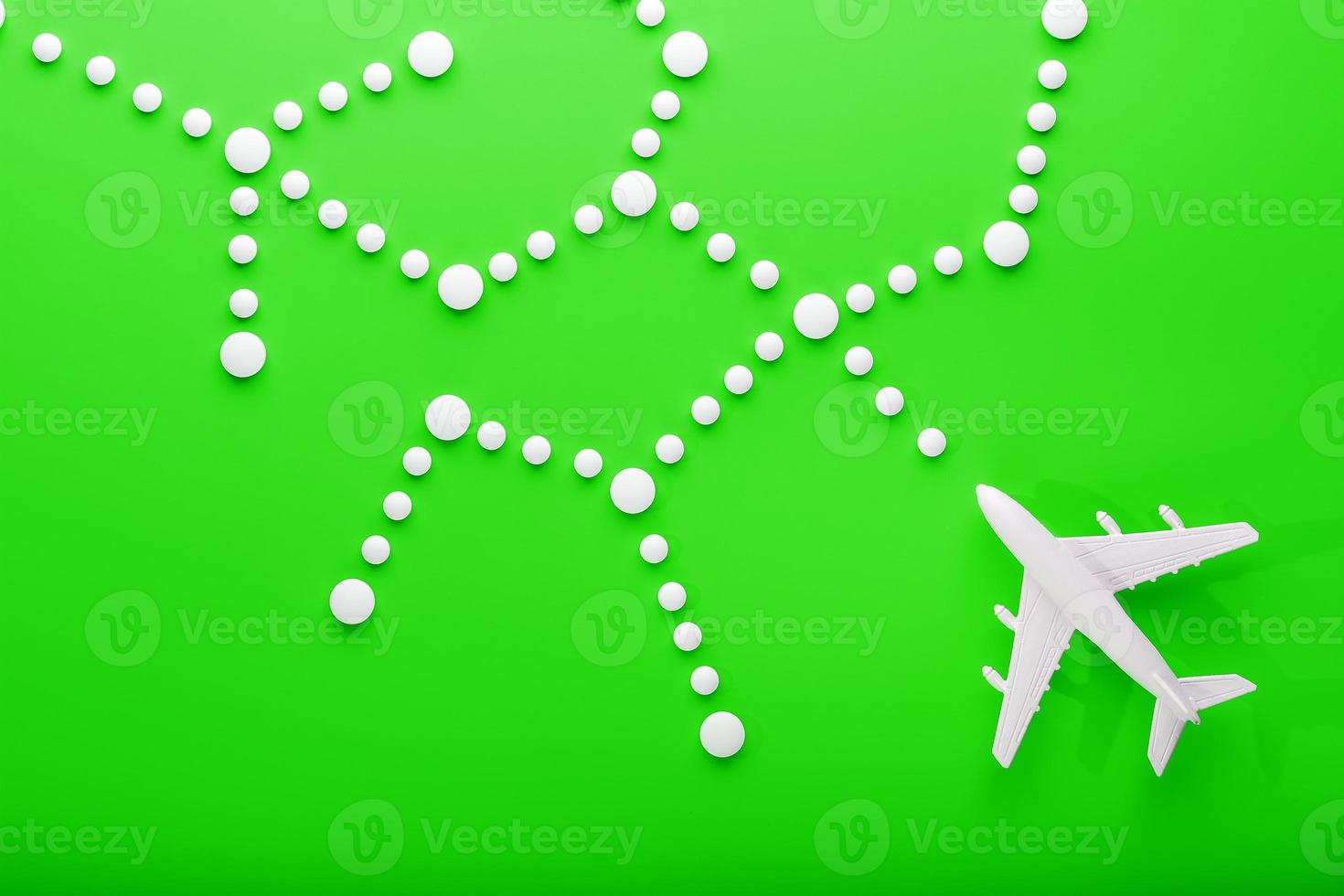 avión de pasajeros blanco con puntos de trayectoria como en un mapa de ruta, aislado con un fondo verde brillante. foto