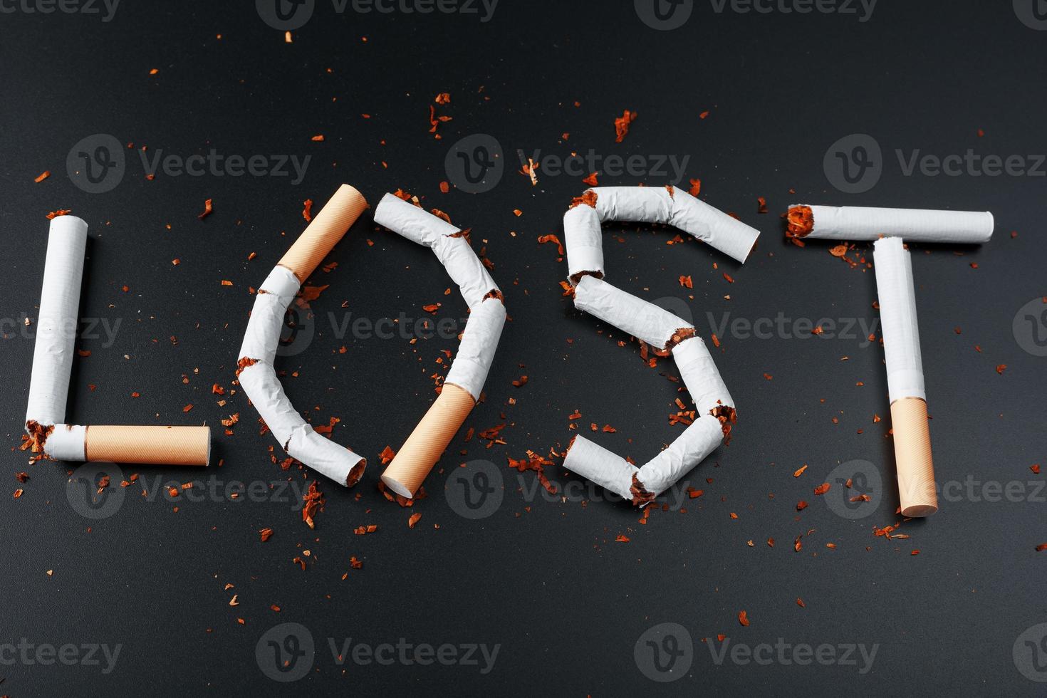 The inscription LOST from cigarettes on a black background. Stop smoking. The concept of smoking kills. Motivation inscription to quit smoking, unhealthy habit. photo