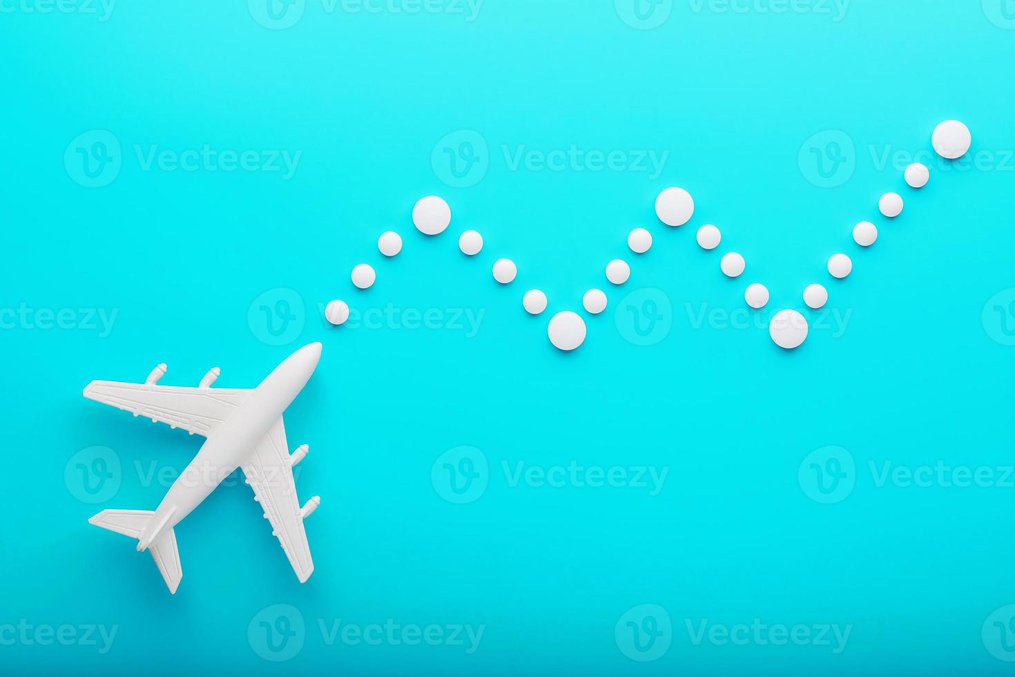 White plane on a blue background with a flexible and smooth trajectory of the route from white points. photo