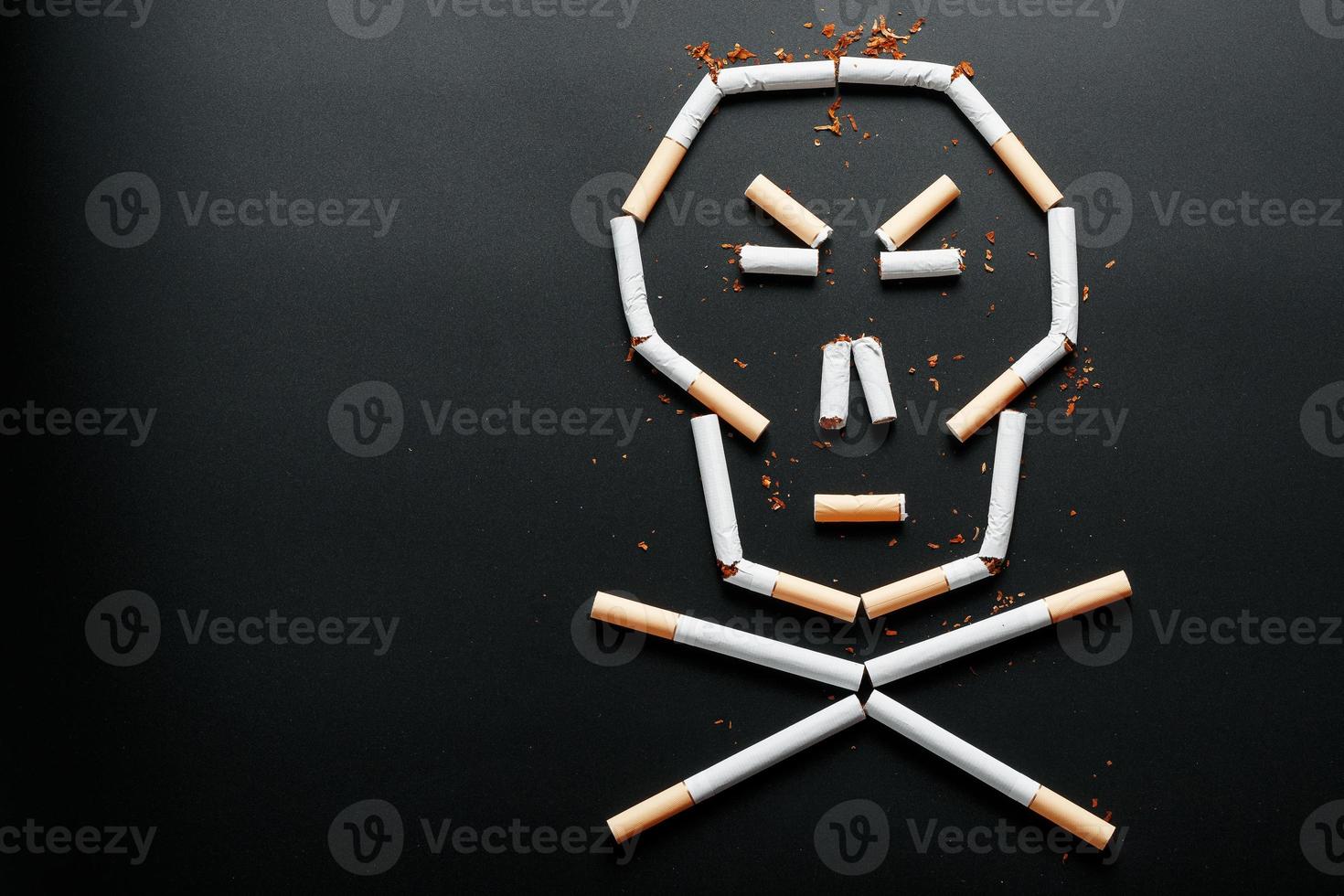 Skull from cigarettes on a black background. The concept of smoking kills. Toward the concept of smoking as a deadly habit, nicotine poisons, cancer from smoking, illness, quit smoking. photo