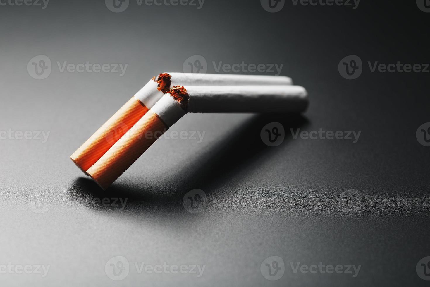 dos cigarrillos en forma de escopeta de dos cañones sobre un fondo negro con espacio para copiar. deja de fumar. el concepto de fumar mata. foto