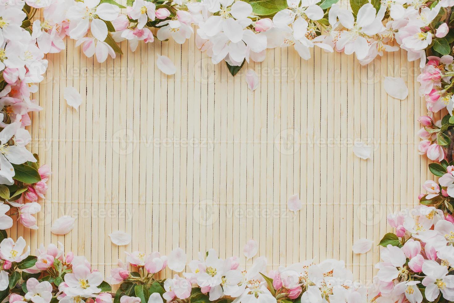 Frame of spring flowers of sakura on bamboo background. Beautiful cherry blossom sakura in springtime Low contrast photo