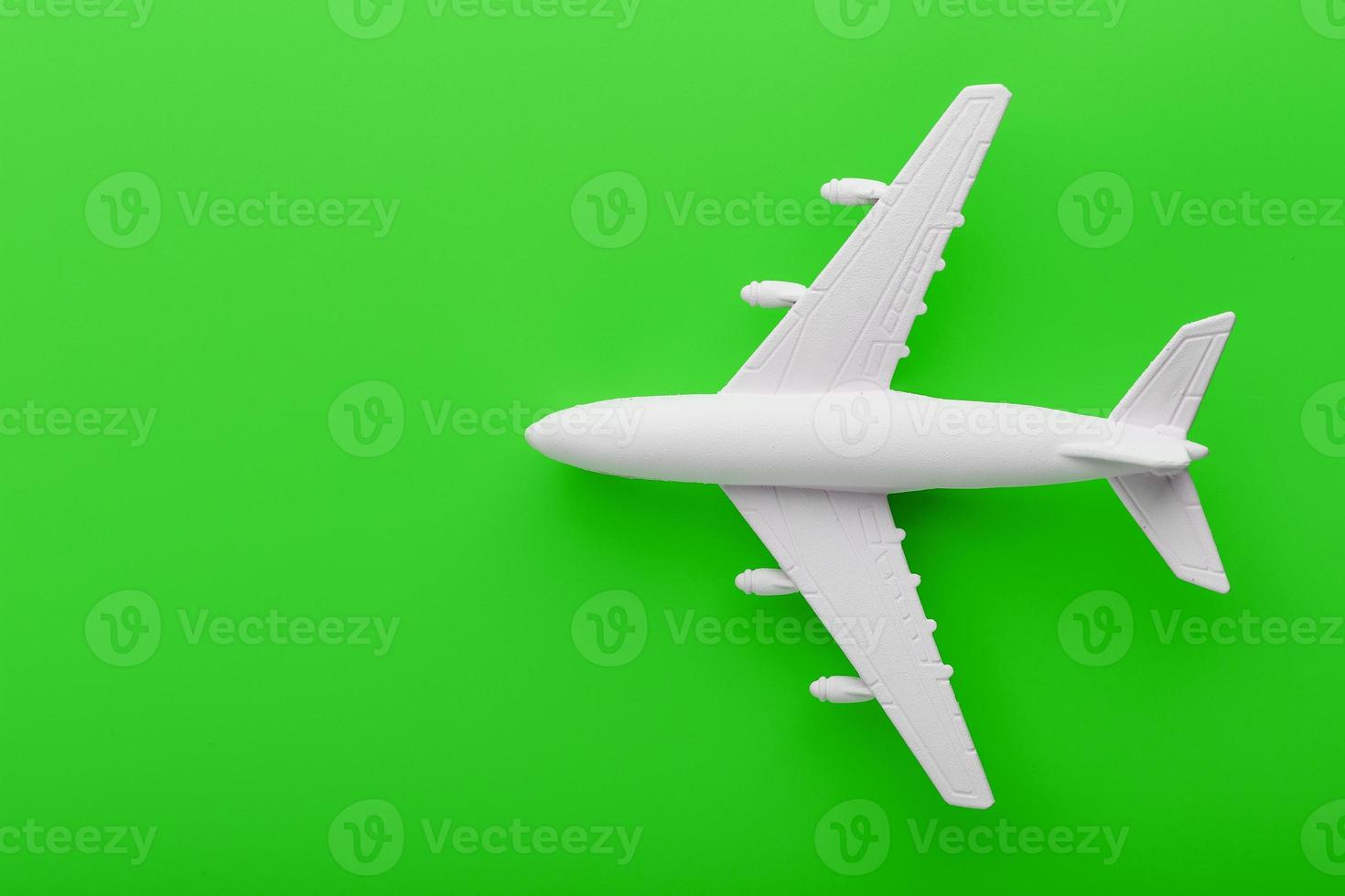 modelo de avión de pasajeros blanco sobre un fondo verde brillante. espacio libre para texto. foto